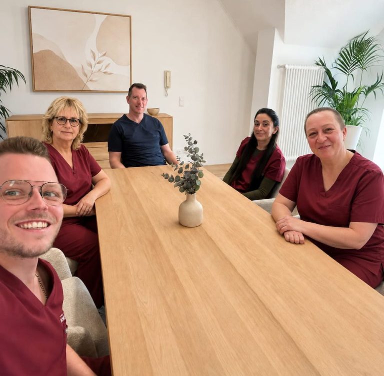 Das Team von Rohde & Schmid sitzt gemeinsam an einem Besprechungstisch, in einem hellen Raum.