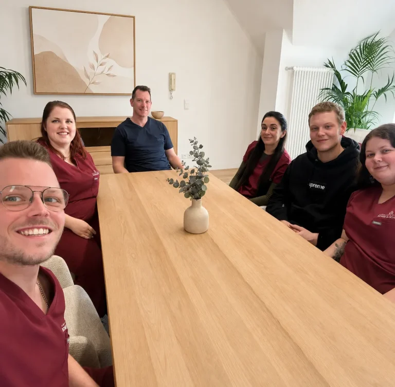 Das Team von Rohde & Schmid sitzt gemeinsam an einem Besprechungstisch, in einem hellen Raum.